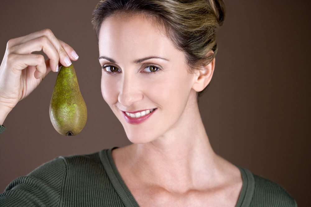 Woman enjoying a pear as a healthy aphrodisiac.